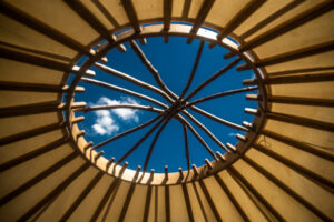View upward through a yurt roof opening to the sky.